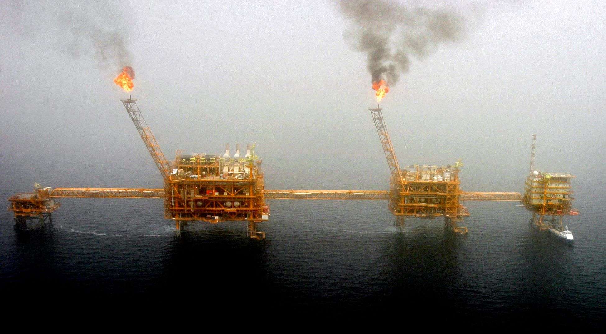 شعلات من الغاز تنبعث من منصات في حقل "سوروش" لإنتاج النفط، جنوب طهران. بتاريخ 25 يوليو 2005 