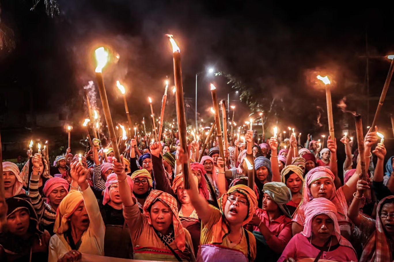 نساء منتسبات إلى "ميرا بايبس" وهي مجموعة من النساء اللائي يمثلن مجموعة "ميتي" يحملن المشاعل خلال تظاهرة في إمفال تطالب بإحلال السلام من جديد في ولاية مانيبور شمال شرقي الهند (أ ف ب/غيتي)