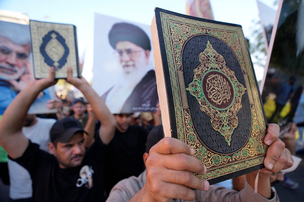 Iraqis raise copies of the Quran, the holy book of Islam, during a protest in Baghdad_ap.jpg