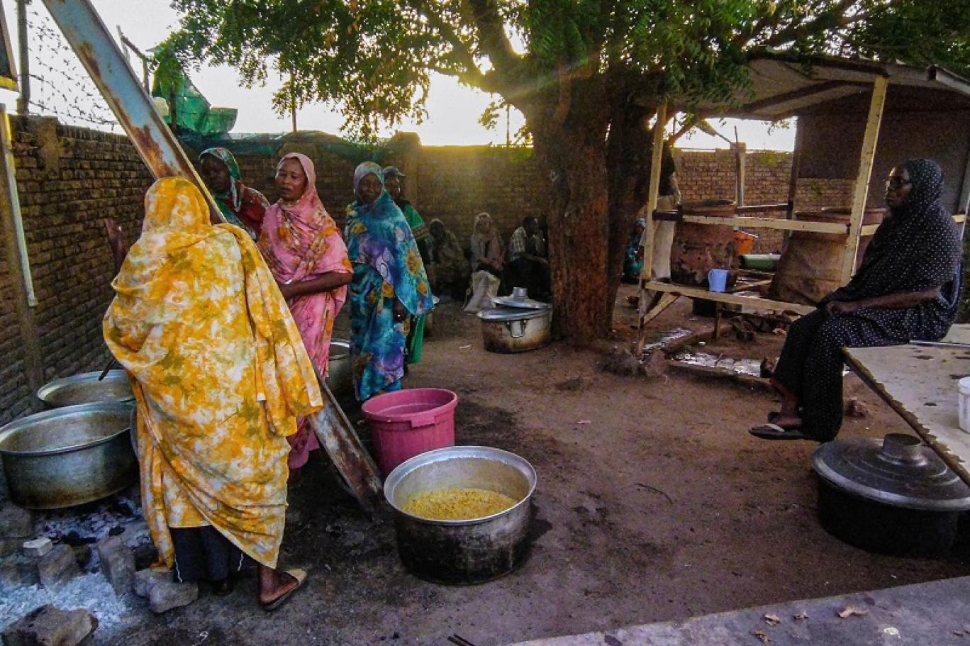 متطوعون يطهون الطعام للنازحين السودانيين في مدينة ود مدني (أ ف ب).jpg