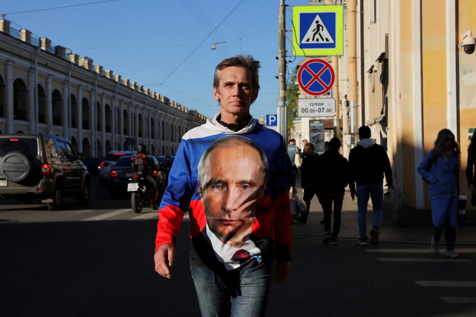 رجل يرتدي قميصاً عليه صورة الرئيس الروسي فلاديمير بوتين، سانت بطرسبرغ، مايو 2022 (أنطون فاغانوف / رويترز)