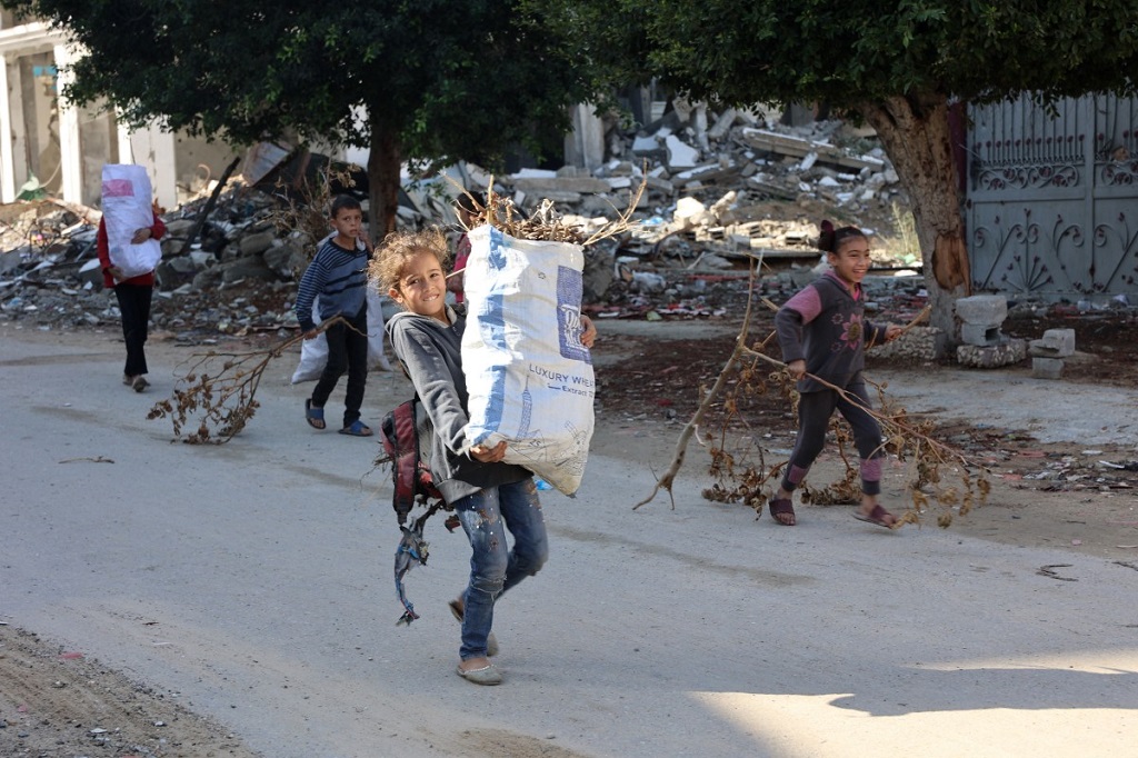 أطفال فلسطينيون يحملون الحطب إلى منازلهم في جباليا شمال قطاع غزة، 20 نوفمبر 2024 (أ ف ب).jpg