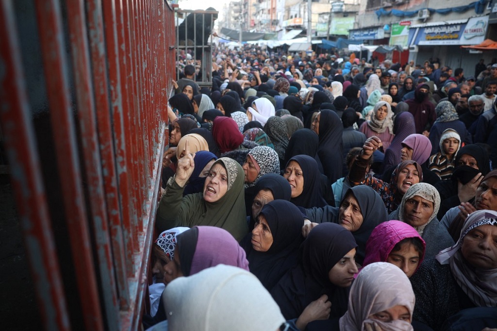 فلسطينيون ينتظرون الخبز خارج مخبز في مخيم النصيرات، 27 نوفمبر 2024 (أ ف ب).jpg